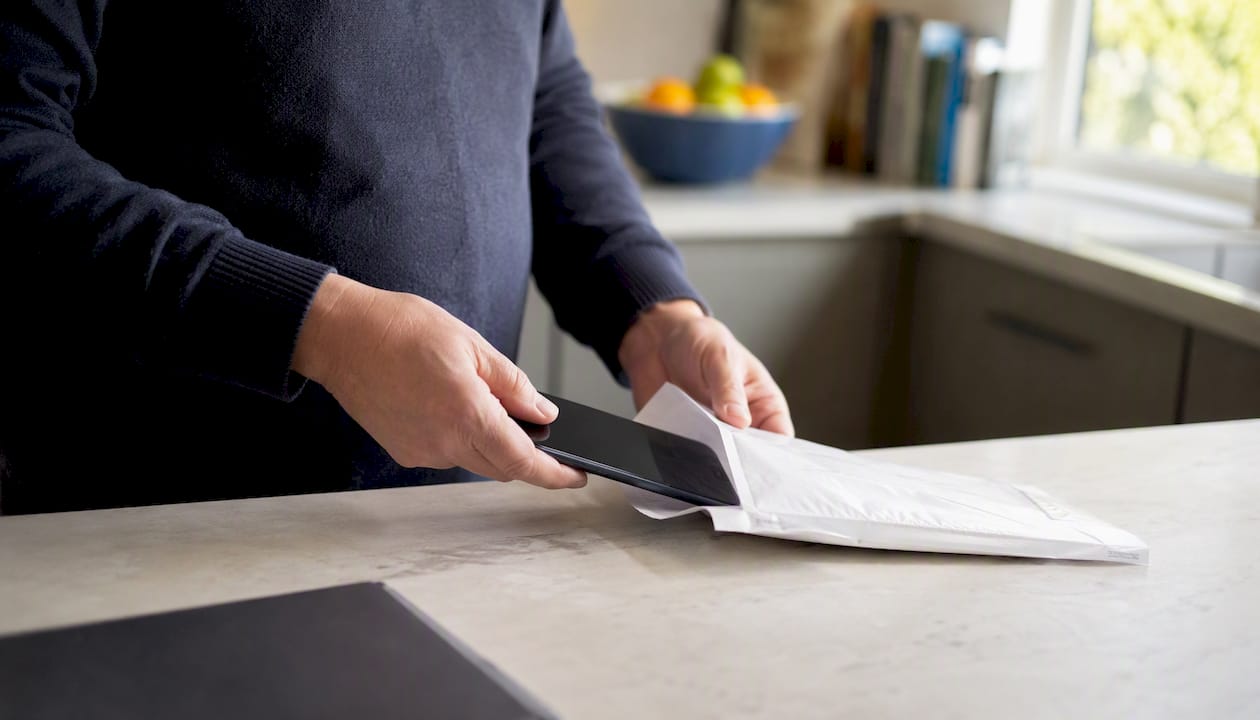 Hands placing phone in evidence bag