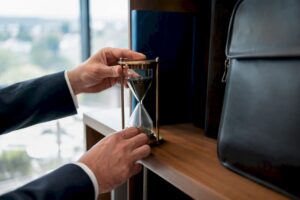 Hands setting clock on legal office table